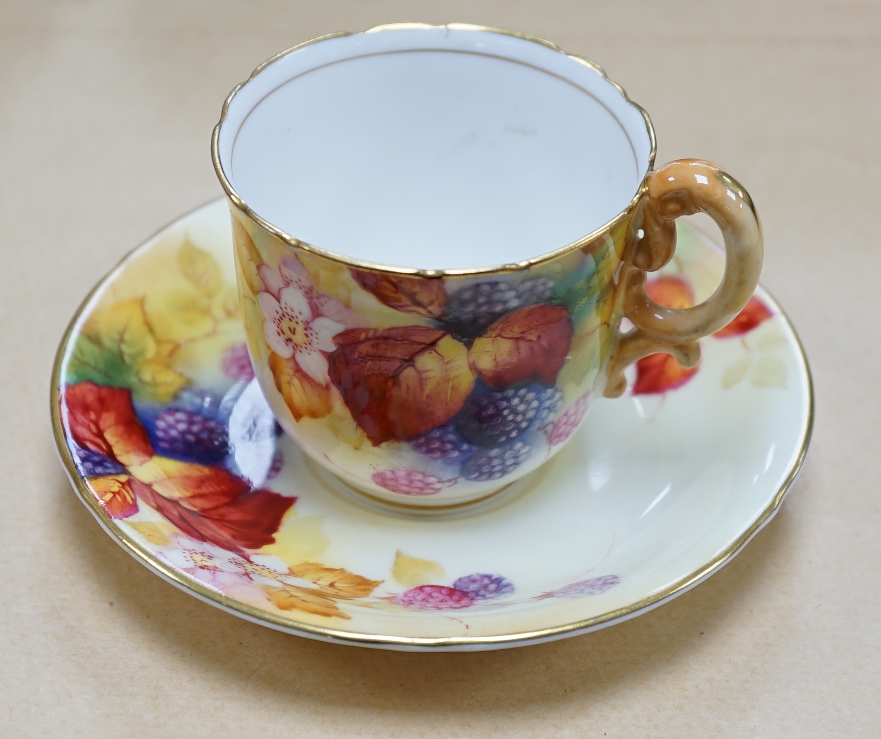 A Royal Worcester fruit painted cup and saucer by Kitty Blake, saucer 11.5cm diameter. Condition - good